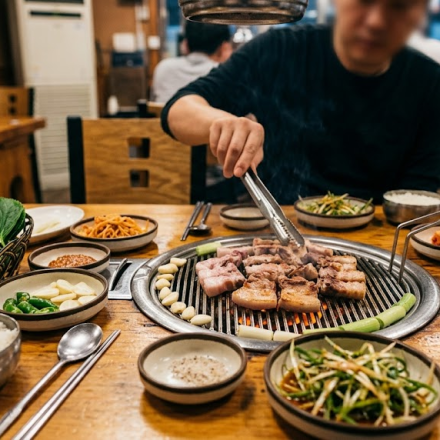 samgyeopsal name meaning Korean barbecue table with pork belly cooking on the grill